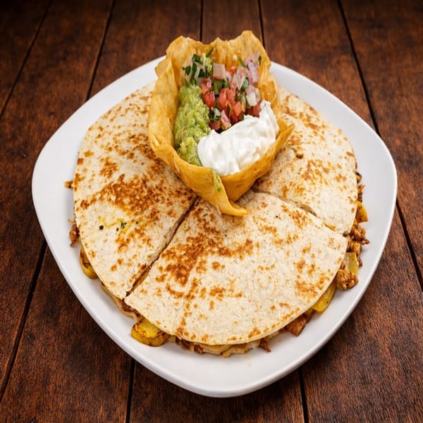 Quesadilla cut into quarters, served with a tortilla bowl of guacamole, pico de gallo, and sour cream.